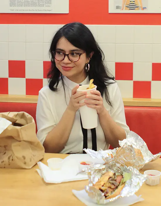 Judy Monsiváis con un vaso de refresco y actitud curiosa